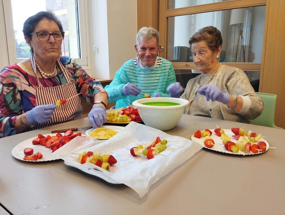 tres residente preparan unos pinchos entre risas